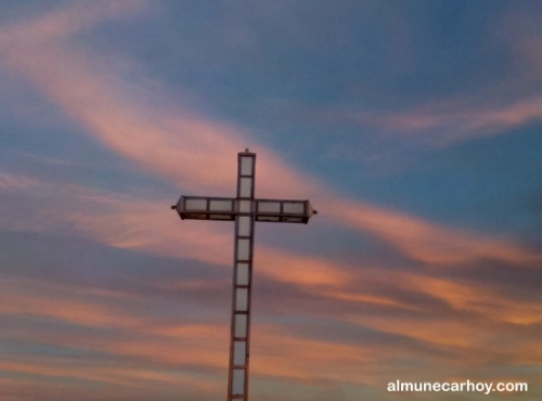 Cruz del Peñón del Santo en Almuñécar al atardecer con cielo anaranjado