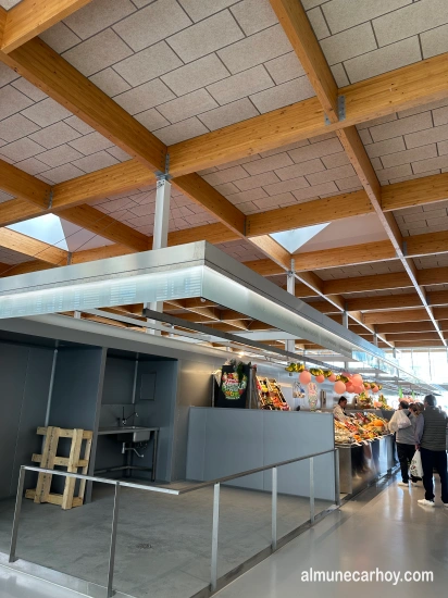 Mercado de Almuñécar 3 Puestos de frutas y verduras en el interior del Mercado Municipal de Almuñécar, con techo de madera y lucernarios