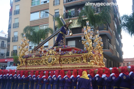 Nuestro Padre Jesús Nazareno portando la cruz sobre el trono llevado por horquilleros