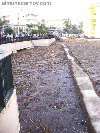 Inundaciones de septiembre de 2007 en Almuñécar 5 Cauce urbano junto al acueducto romano de Almuñécar cubierto de barro y cañas tras la riada de septiembre de 2007, con vecinos observando desde la barandilla al fondo.
