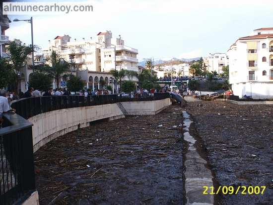 Cauce urbano junto al acueducto romano de Almuñécar cubierto de barro y restos de la riada, con numerosos vecinos observando desde la barandilla el 21 de septiembre de 2007