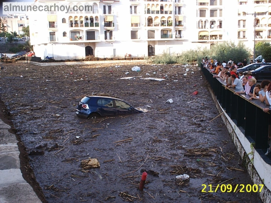 Turismo observando desde la barandilla un coche semienterrado en barro y cañas en el entorno del acueducto romano de Almuñécar tras la riada del 21 de septiembre de 2007.