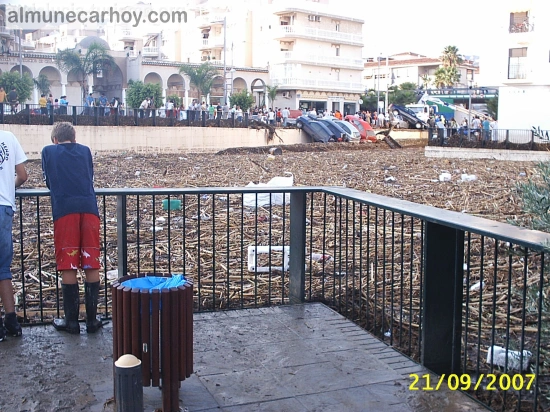 Personas apoyadas en la barandilla observando el cauce colmatado de cañas, barro y restos junto al acueducto romano de Almuñécar tras la riada del 21 de septiembre de 2007.
