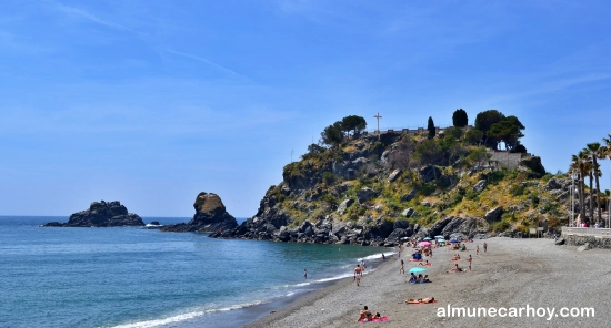 Peñón del Santo en Almuñécar con la cruz en su mirador y playa de San Cristóbal en primer plano